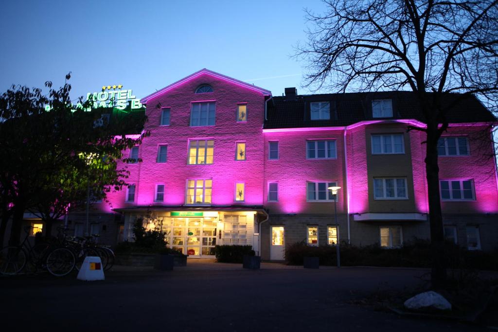 un edificio con luces rosas en el lateral. en Hotel Mölndals Bro, en Mölndal