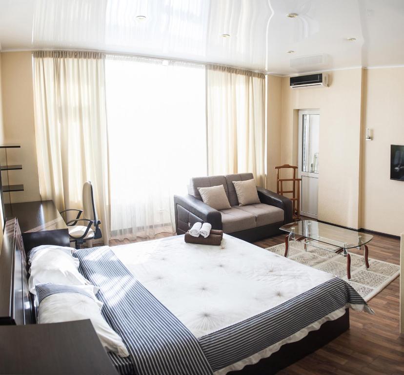 Apartment on Kunayeva 38 في شيمكنت: غرفة معيشة مع سرير كبير وأريكة