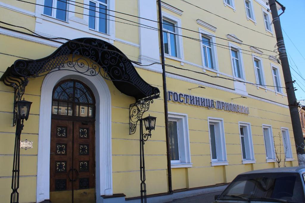 a yellow building with a door and a sign on it at Priokskaya Hotel in Ryazan