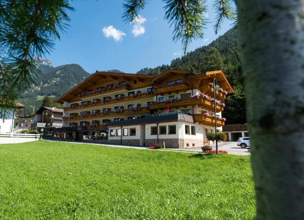 ein großes Gebäude mit grünem Rasen davor in der Unterkunft Hotel Huber Hochland in Maurach