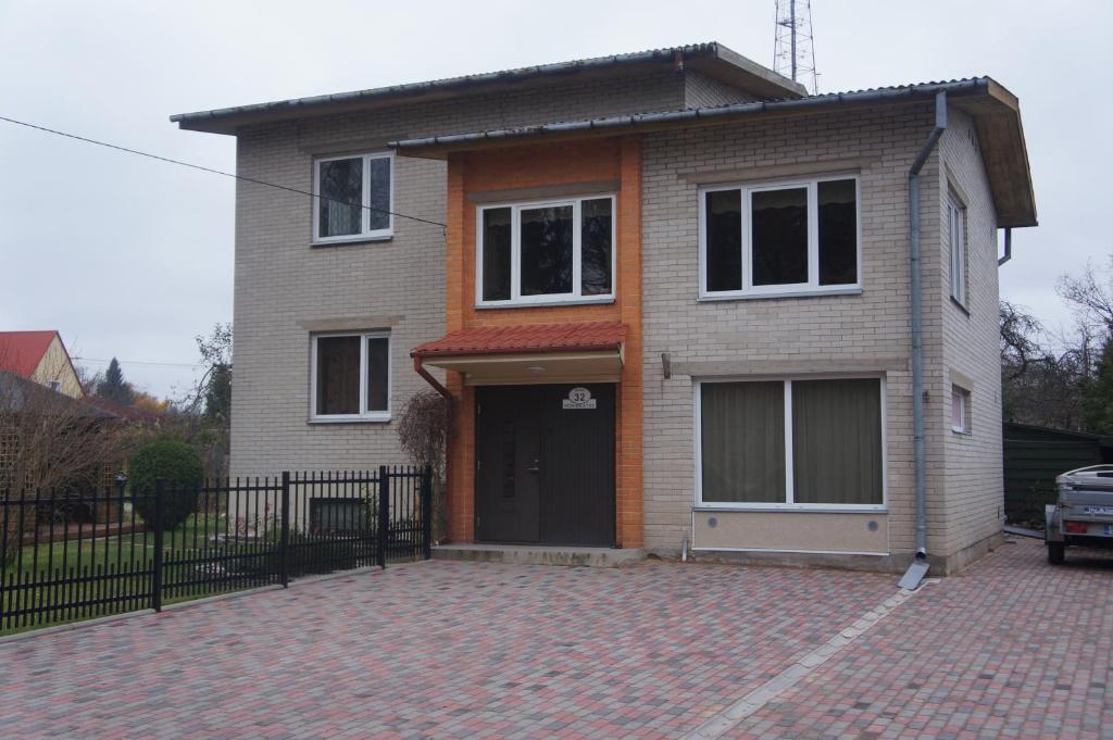 a house with a black door on a brick driveway at VIIVE KONI Home Accommodation in Tartu