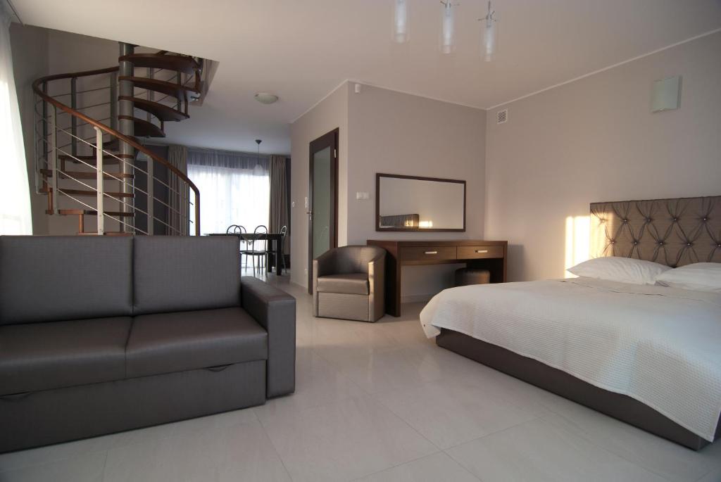 ein Schlafzimmer mit einem Bett, einem Stuhl und einer Treppe in der Unterkunft Villa BALTICA in Rowy