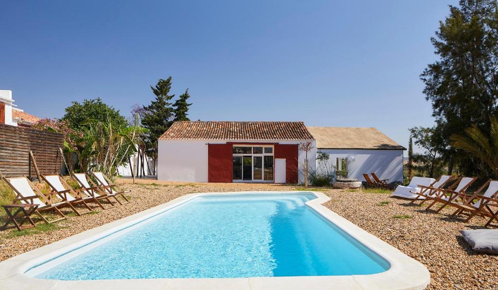 a swimming pool in front of a house at Companhia das Culturas - Ecodesign & Spa Hotel in Castro Marim