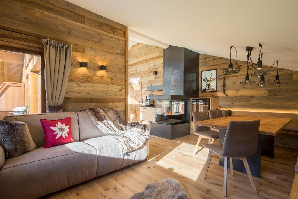 una sala de estar con un sofá y una mesa en Haus Sonnblick Penthouse, en Reith im Alpbachtal