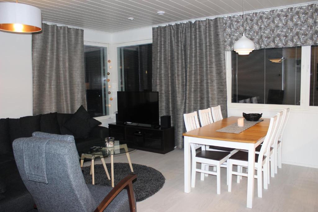 a living room with a table and a dining room at Majoituspalvelu Nurmi Apartment Oksapolku 2 A Deluxe Huoneisto 60m3 in Raahe