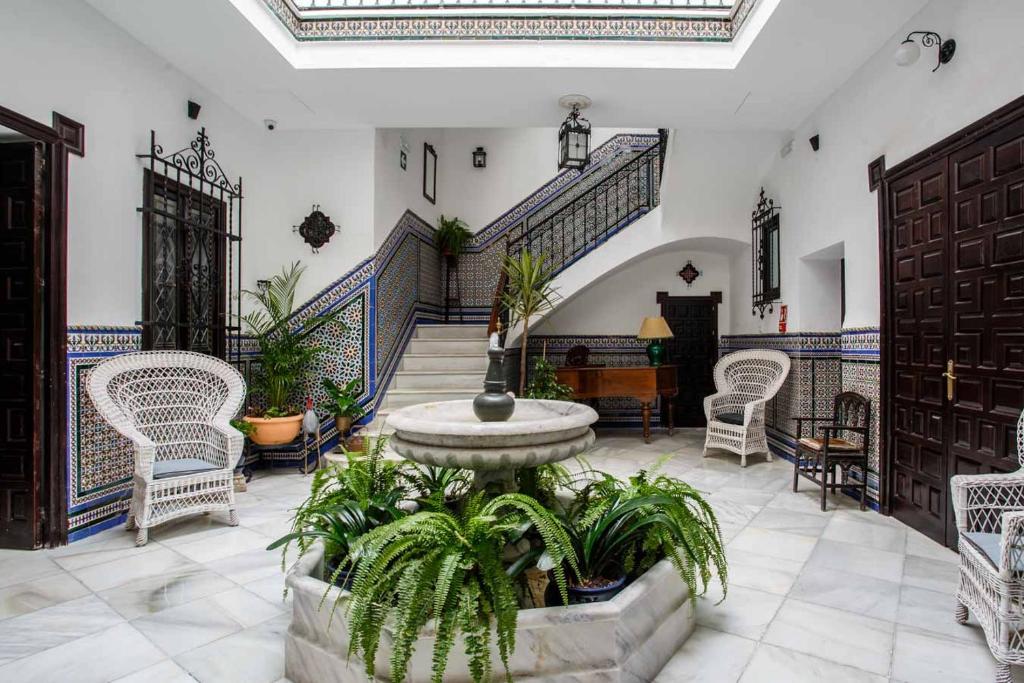 Habitación grande con fuente, sillas y escaleras. en Suites Machado, en Sevilla