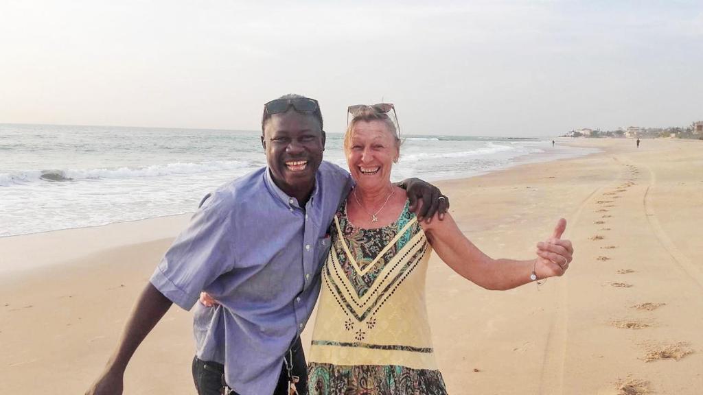 a man and a woman standing on the beach at Keur Dofie in Toubab Dialaw