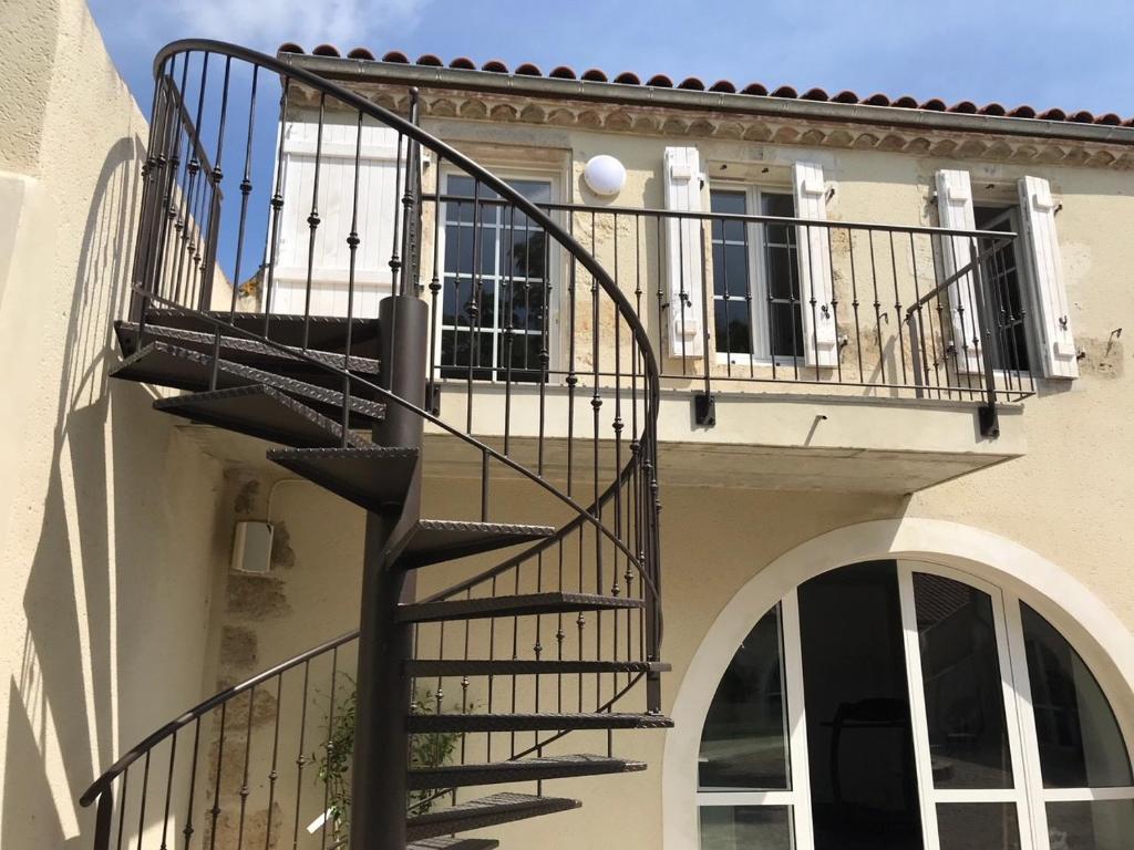 a spiral staircase on the side of a building at Le Continental in Condom