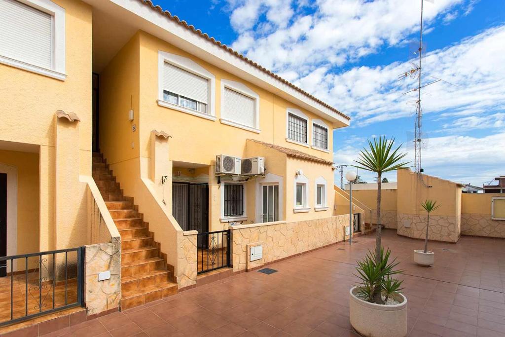 a yellow house with a staircase in front of it at CH Palacios Formentera del Segura in Rojales