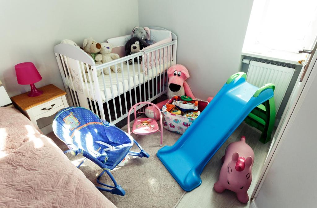 Dormitorio infantil con cuna y juguetes en Apartment Cracow en Cracovia