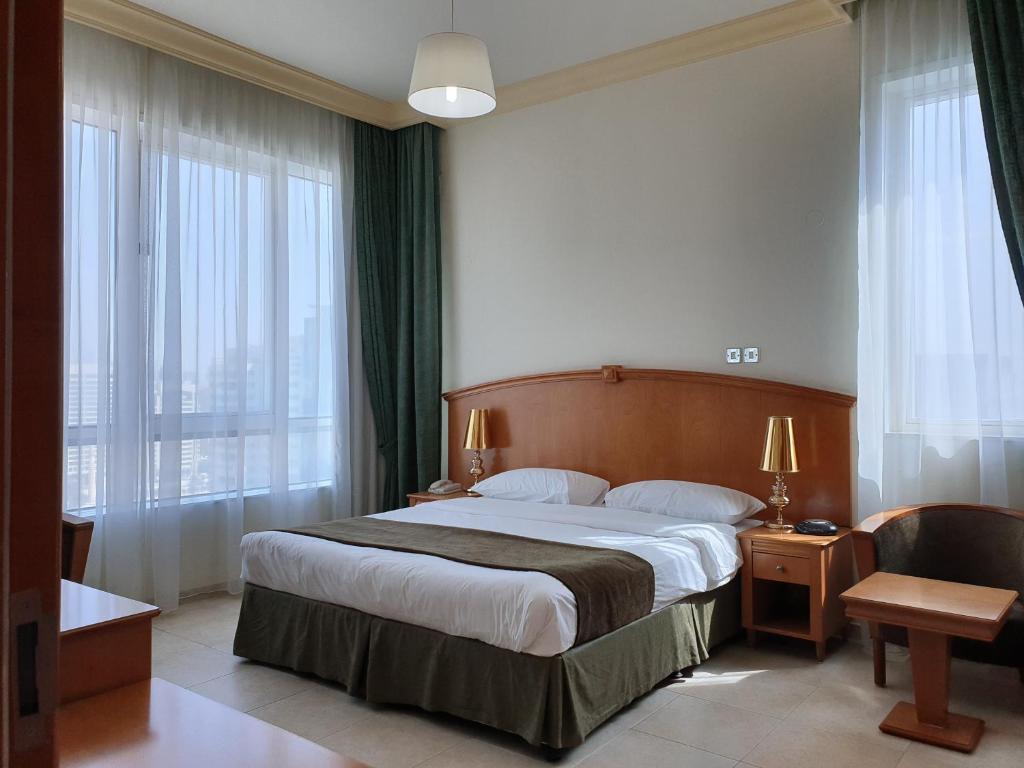 ein Hotelzimmer mit einem Bett und einem großen Fenster in der Unterkunft Platinum Hotel Apartments in Abu Dhabi