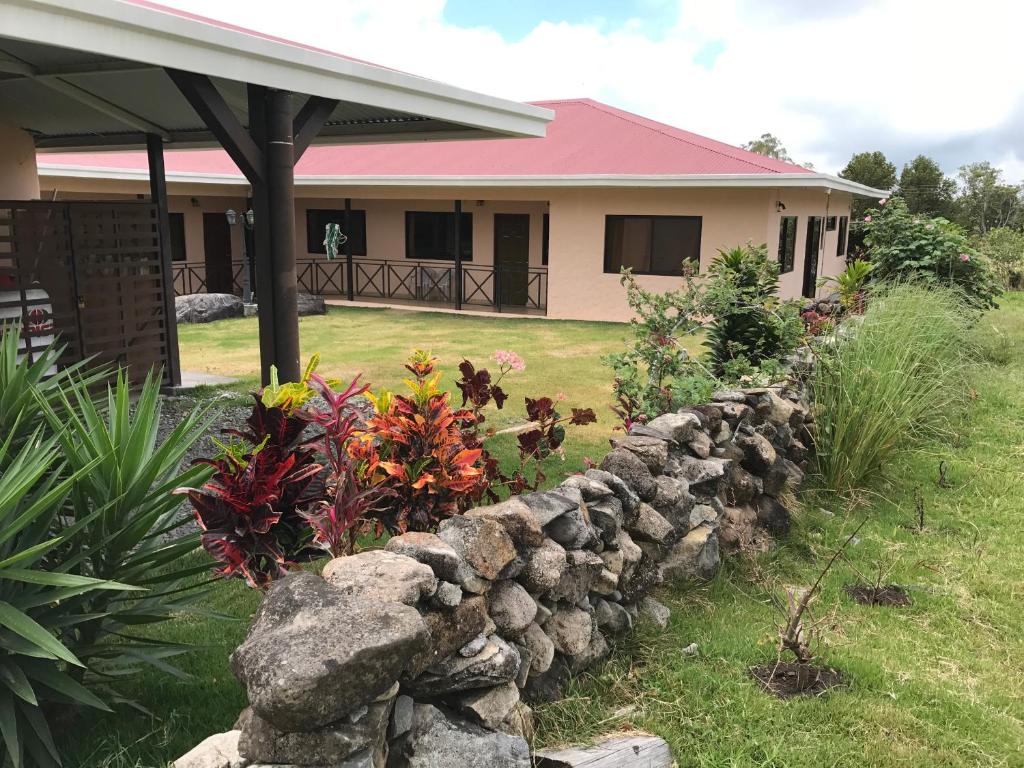 a stone retaining wall in front of a house at Pacandé Apartamentos in Boquete