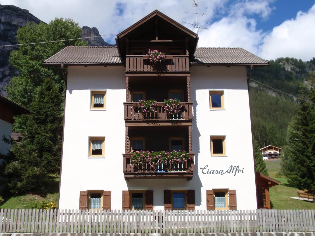 ein weißes Haus mit Blumen auf den Balkonen in der Unterkunft Ciasa Alfri in Stern