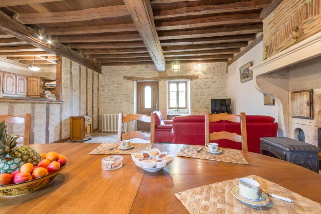 een woonkamer met een houten tafel met fruit erop bij L'Hirondelle in Lantilly