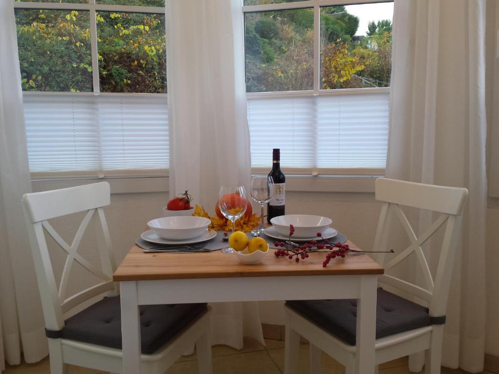 uma mesa com duas cadeiras e uma garrafa de vinho em Moderne Wohnung in barockem Altstadthaus nahe Altstadt und Radweg em Blieskastel