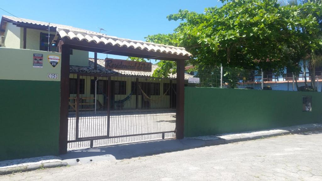una puerta a un edificio con una valla verde en Residencial do Tchê, en Florianópolis