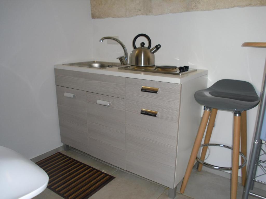 a kitchen counter with a sink and a stool at Romi' in Polignano a Mare