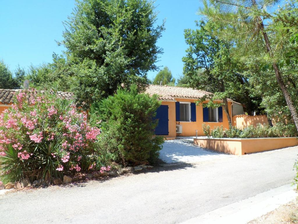une maison avec un jardin et des fleurs devant elle dans l'établissement Villa Célestine, à Roussillon