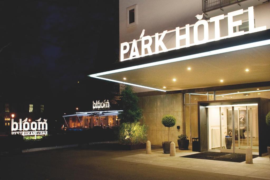 
a store with a neon sign on the front of it at Park Hotel Winterthur in Winterthur
