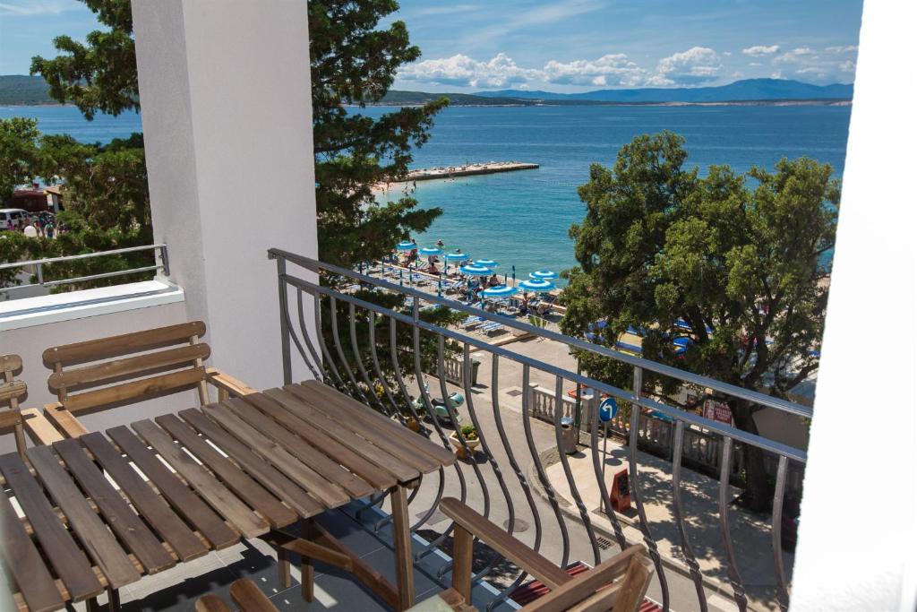 een balkon met een bank en uitzicht op de oceaan bij Apartmani Plaža in Selce