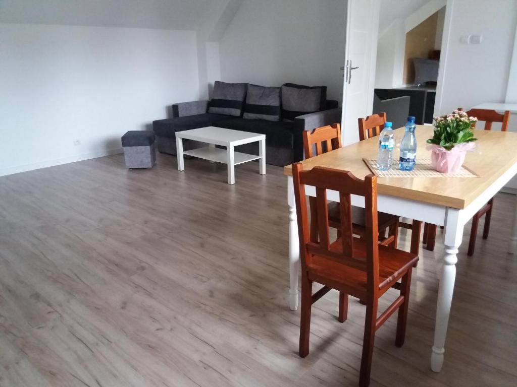 - une salle à manger et un salon avec une table et des chaises dans l'établissement Kuchciak Apartments, à Gdańsk