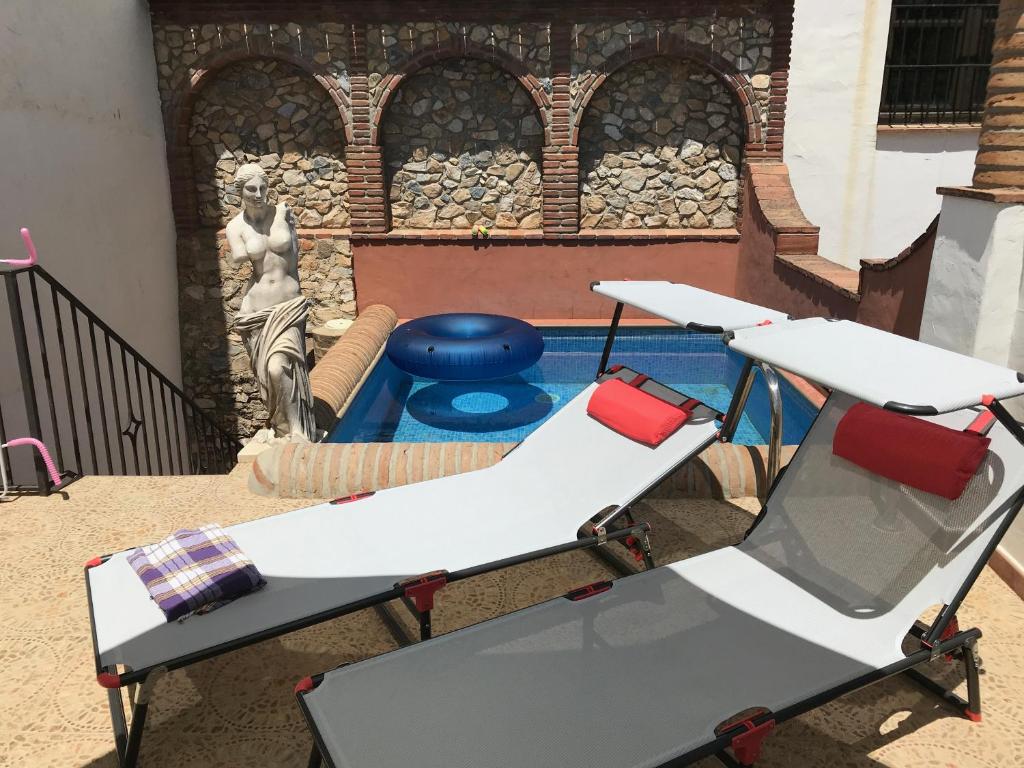 una mesa de picnic y sillas frente a una fuente en B&B the lost Village el Acebuchal en Frigiliana