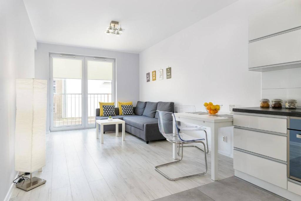 a kitchen and living room with a couch and a table at Good Time Apartments Strzelecka A in Poznań