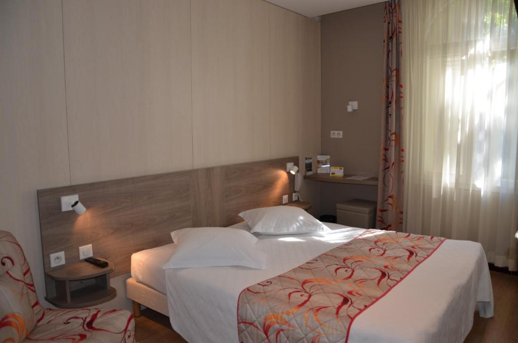 Postel nebo postele na pokoji v ubytování Brit Hotel Confort Le Revest Sainte-Maxime