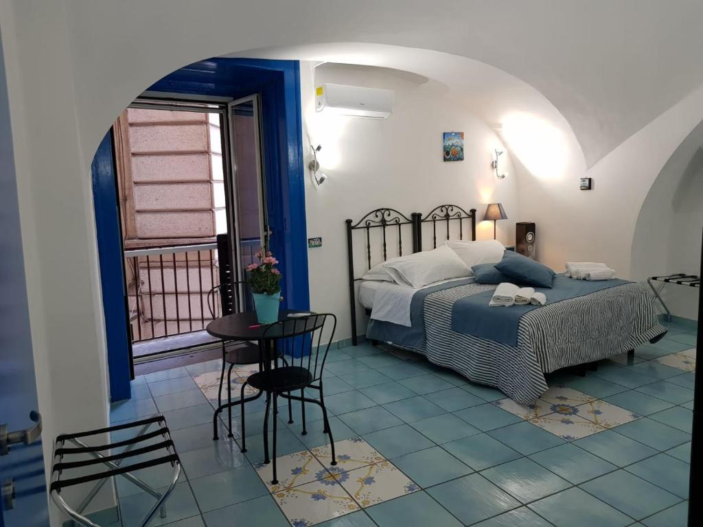 ナポリにあるNapoli Lungomare Caracciolo Mon Amourのベッドルーム1室(ベッド1台、テーブル、椅子付)