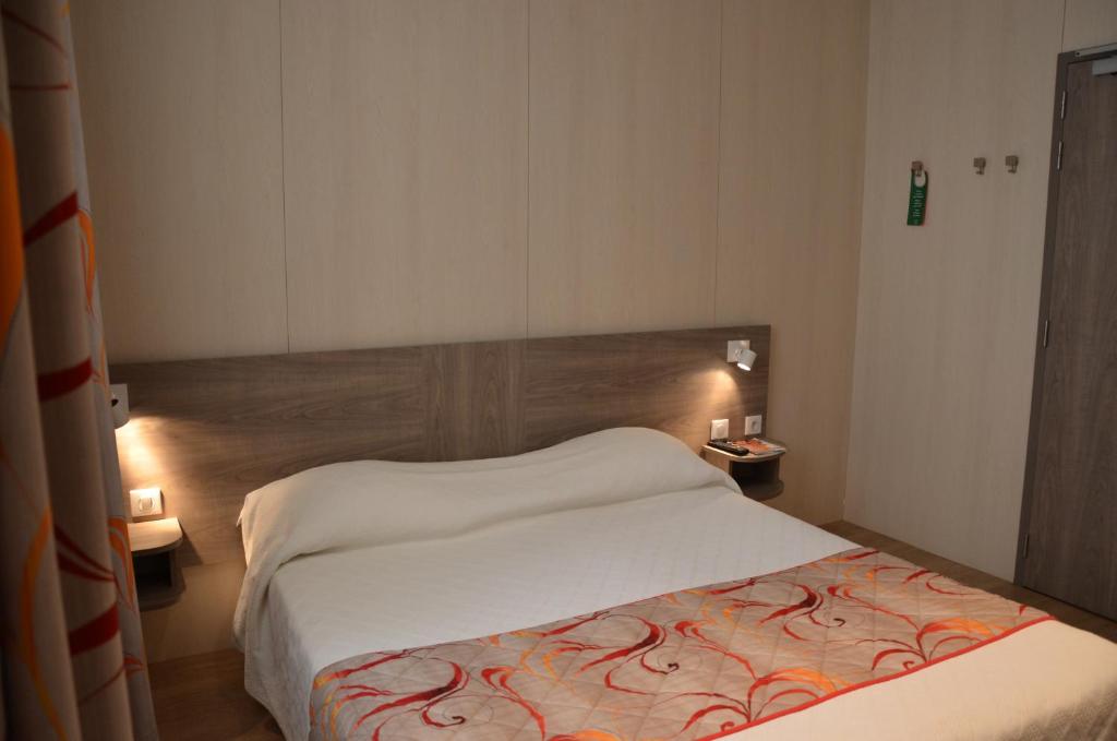 Postel nebo postele na pokoji v ubytování Brit Hotel Confort Le Revest Sainte-Maxime