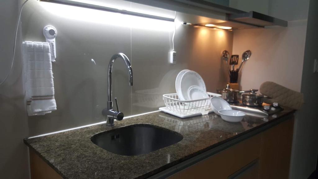 une cuisine avec un évier et un comptoir avec un évier dans l'établissement 101 Newport Boulevard C1, à Manille