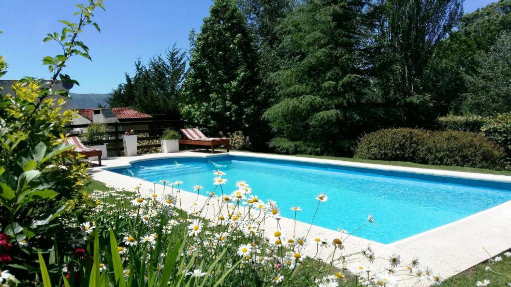 una piscina en un jardín con flores en Lomas del Vergel en Los Reartes