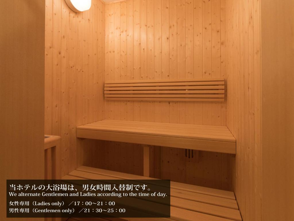 a sauna with wooden walls and a wooden bench at S.Training Center Hotel Osaka in Osaka