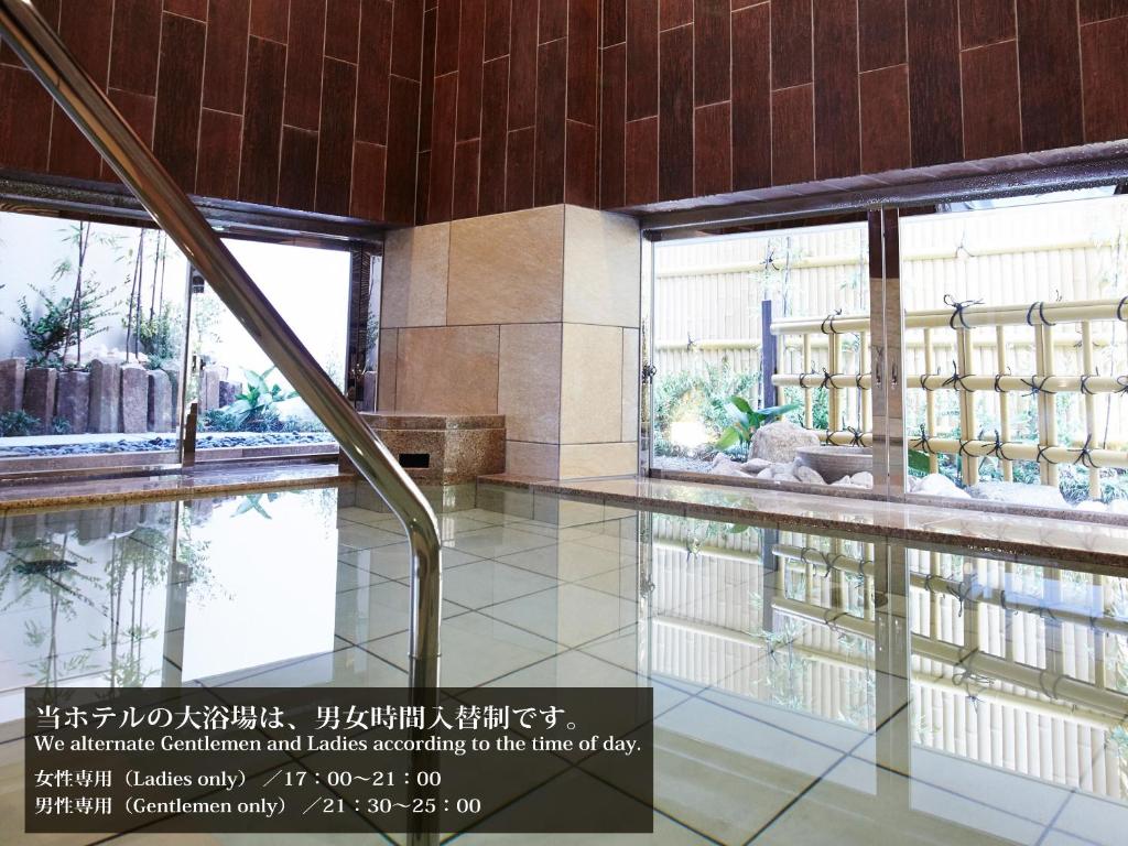 a swimming pool in a building with windows at S.Training Center Hotel Osaka in Osaka