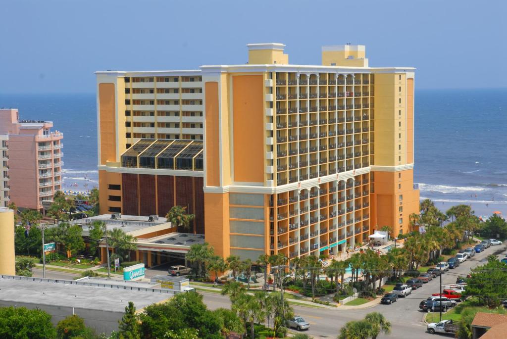 un gran edificio amarillo junto al océano en Caravelle Resort en Myrtle Beach