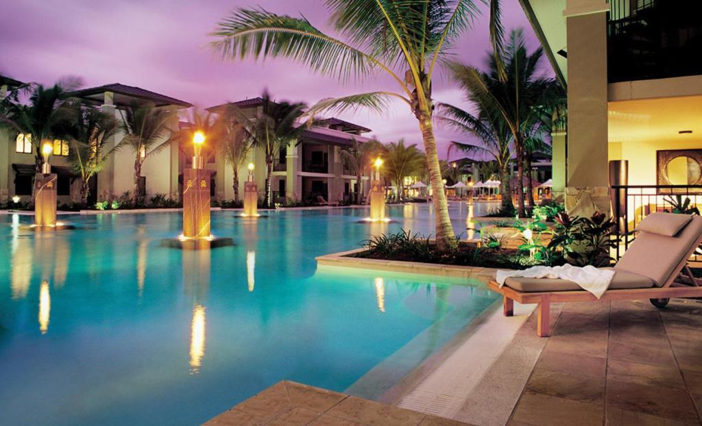 a swimming pool at a resort at night at Temple Resort & Spa Port Douglas in Port Douglas