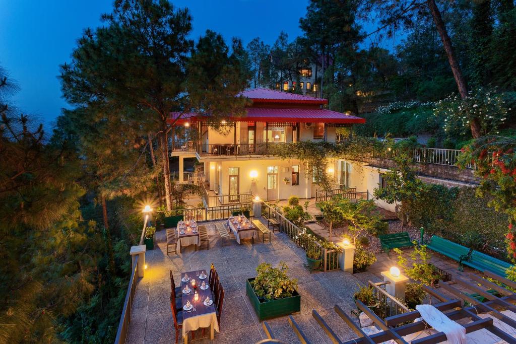 a house with a patio with tables and chairs at 7 Pines Kasauli in Kasauli