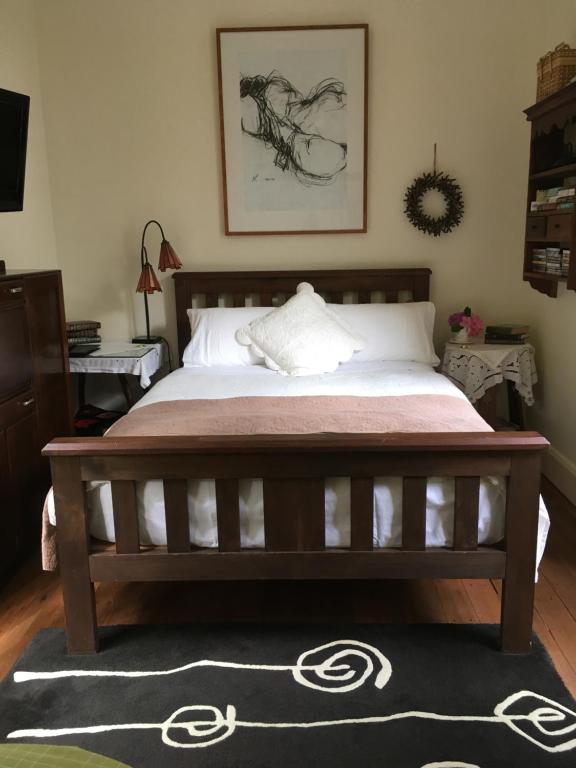 a bedroom with a large bed with a pink blanket at Belgrave Hideaway in Belgrave