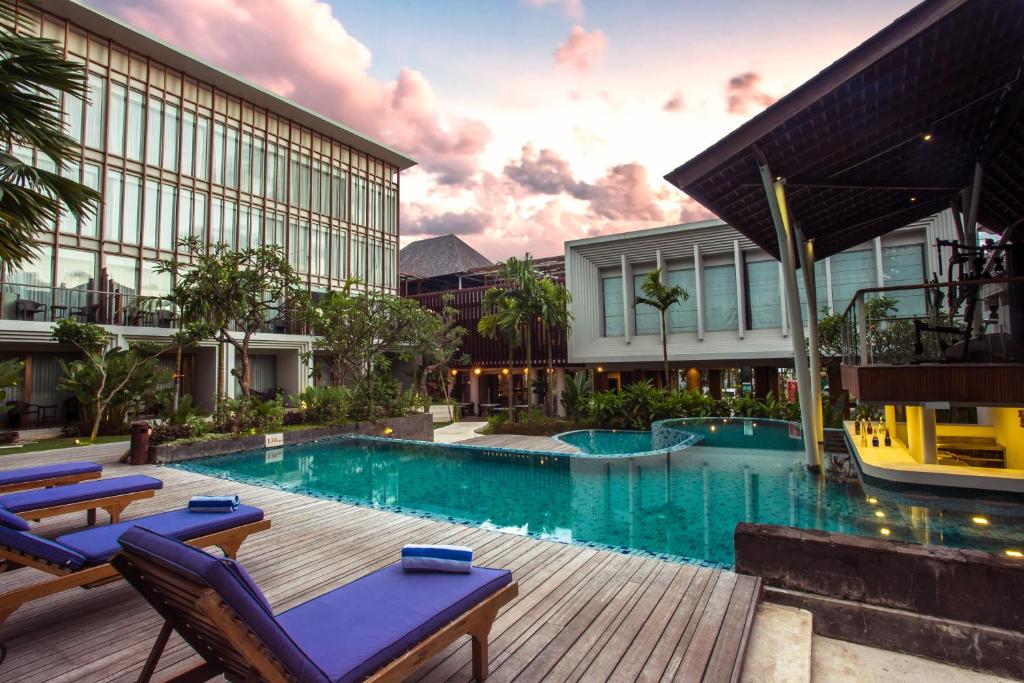 una piscina con sedie e un edificio di The Lerina Hotel Nusa Dua a Nusa Dua