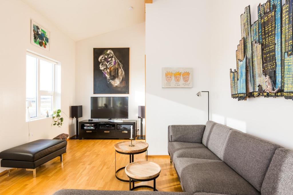 uma sala de estar com um sofá e uma televisão em Kvöldstjarnan Gistiheimili em Stokkseyri