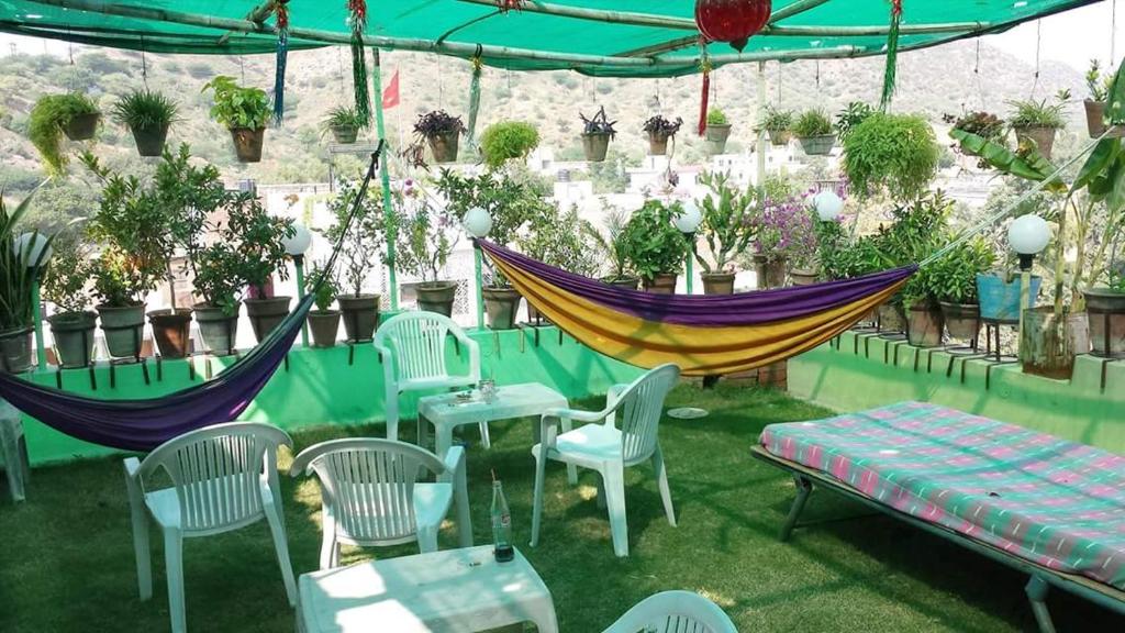 a patio with hammocks and chairs and potted plants at Milkman Guest House in Pushkar