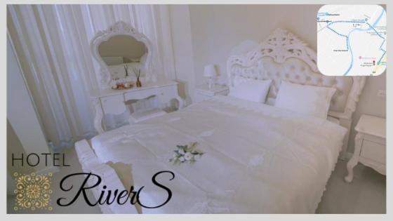 a bedroom with a white bed with a flower on it at River S hotel in Zugdidi