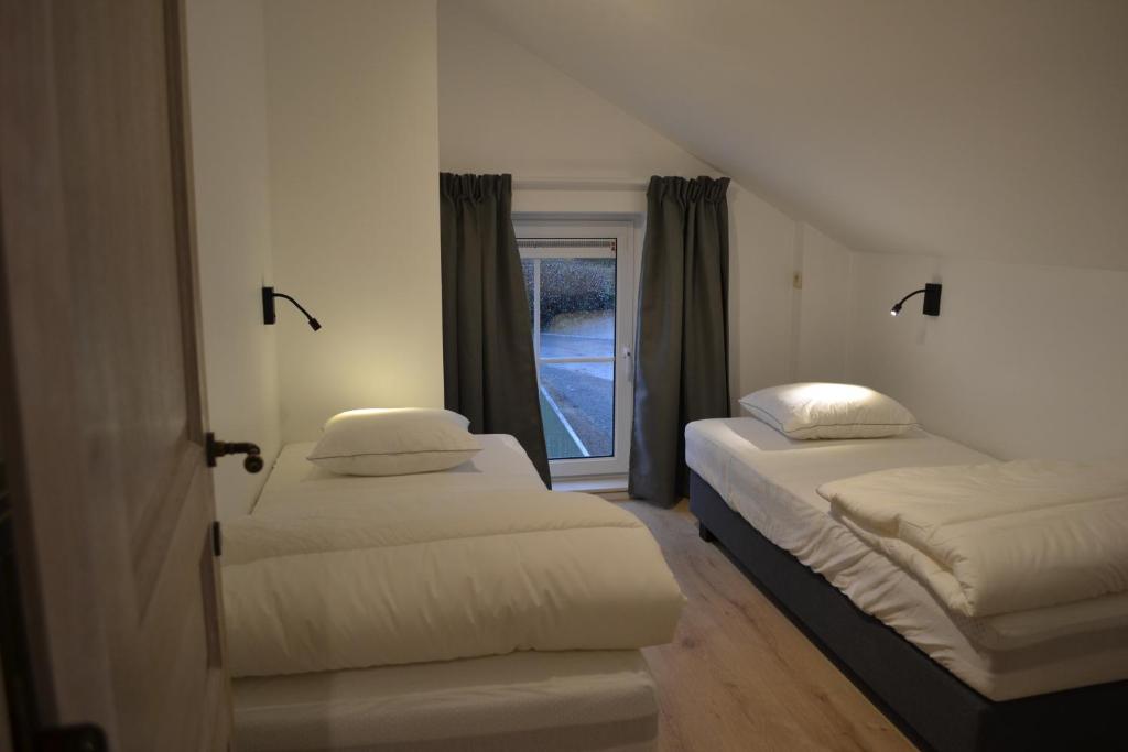 two beds in a room with a window at Vue d'en Haut in Durbuy