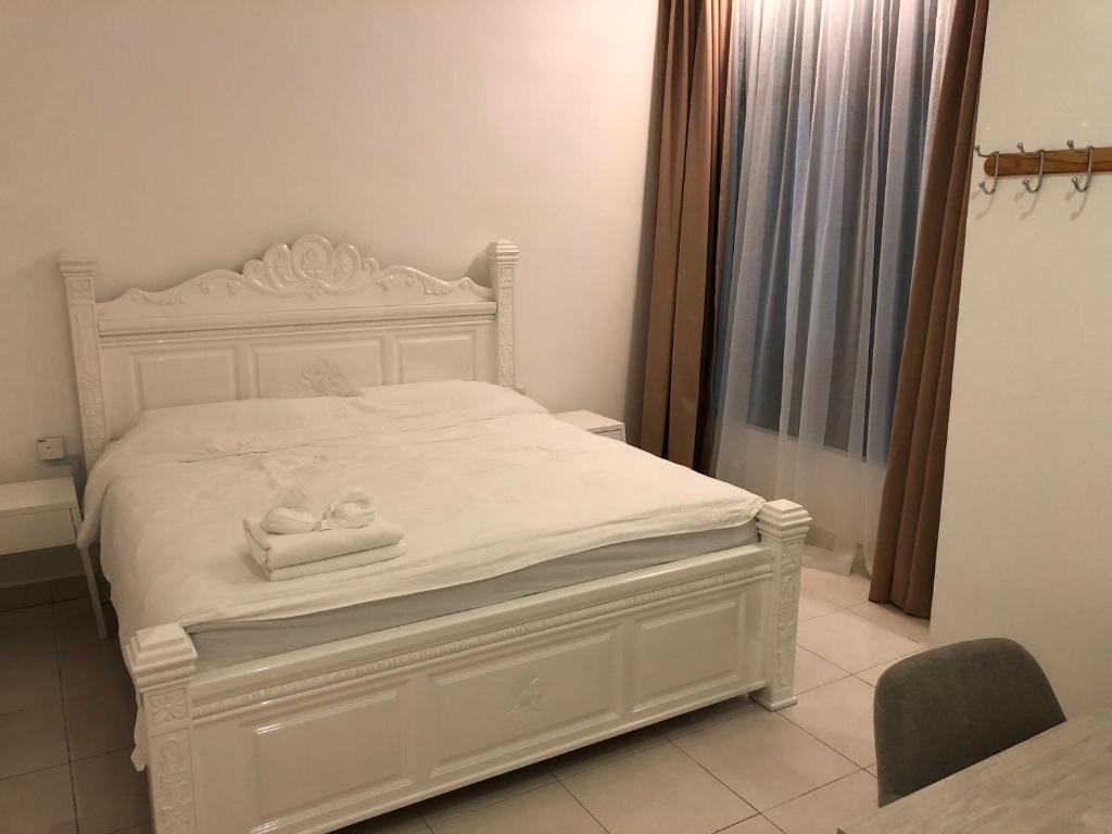 a white bed with two towels on it in a room at Brand New Apartment in Local Neighbourhood in Ringlet