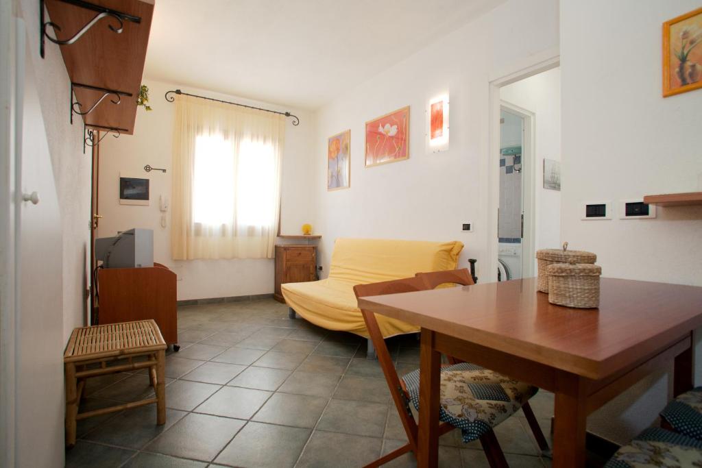 サンタ・テレーザ・ガッルーラにあるBilocale Via Cairoliのリビングルーム(テーブル、黄色のベッド付)