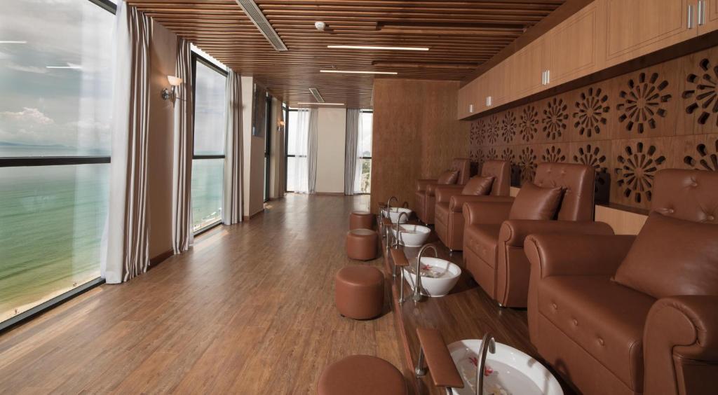A window-lined waiting lounge has leather armchairs and sea-facing glazing.
