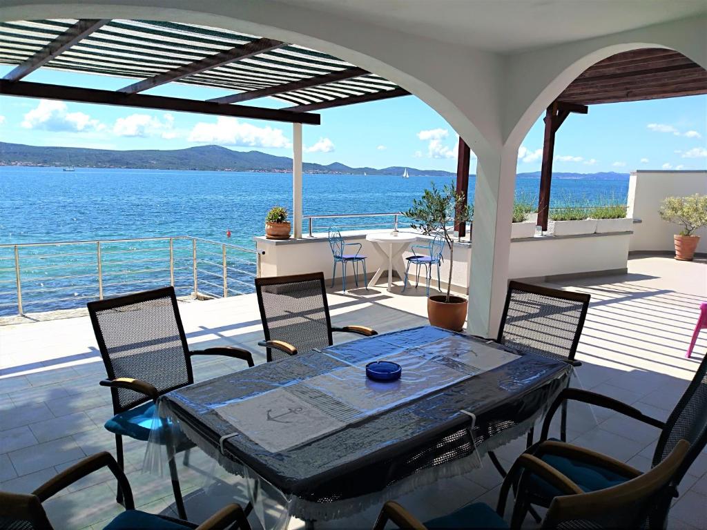 uma mesa e cadeiras num deque com vista para a água em Holiday home Poseidon em Sveti Petar