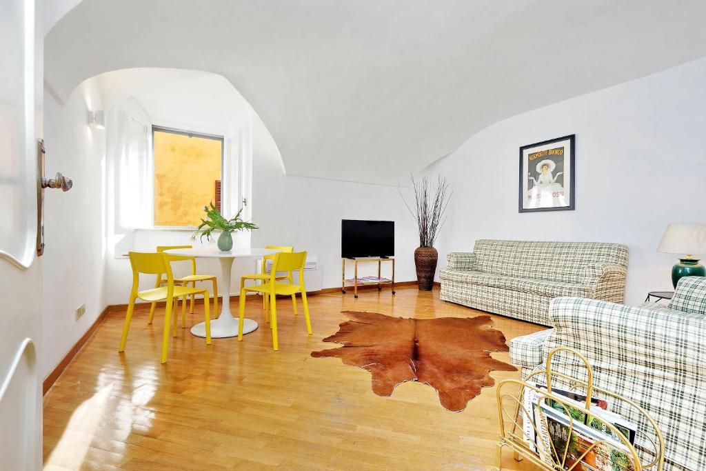 sala de estar con mesa y sillas amarillas en Clementina Charme - My Extra Home en Roma