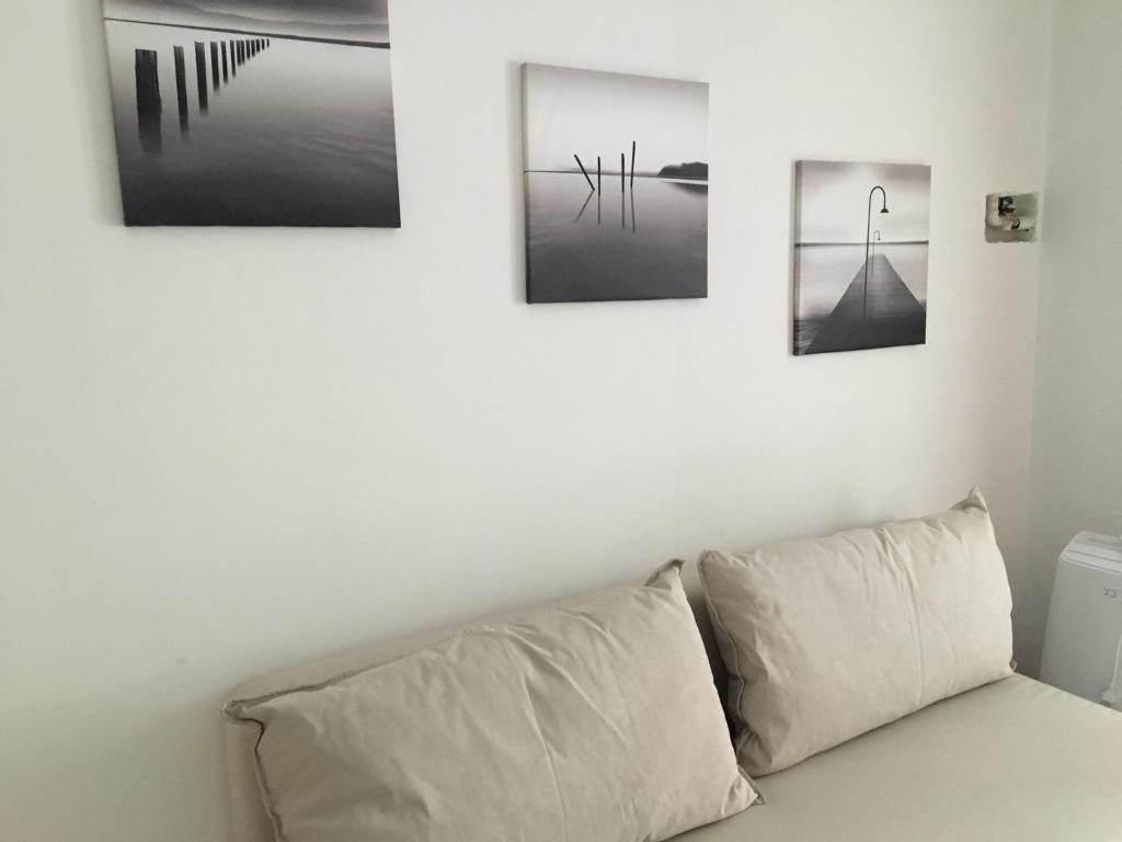 four pictures hanging on a wall above a couch at Casa America in Montesilvano Marina