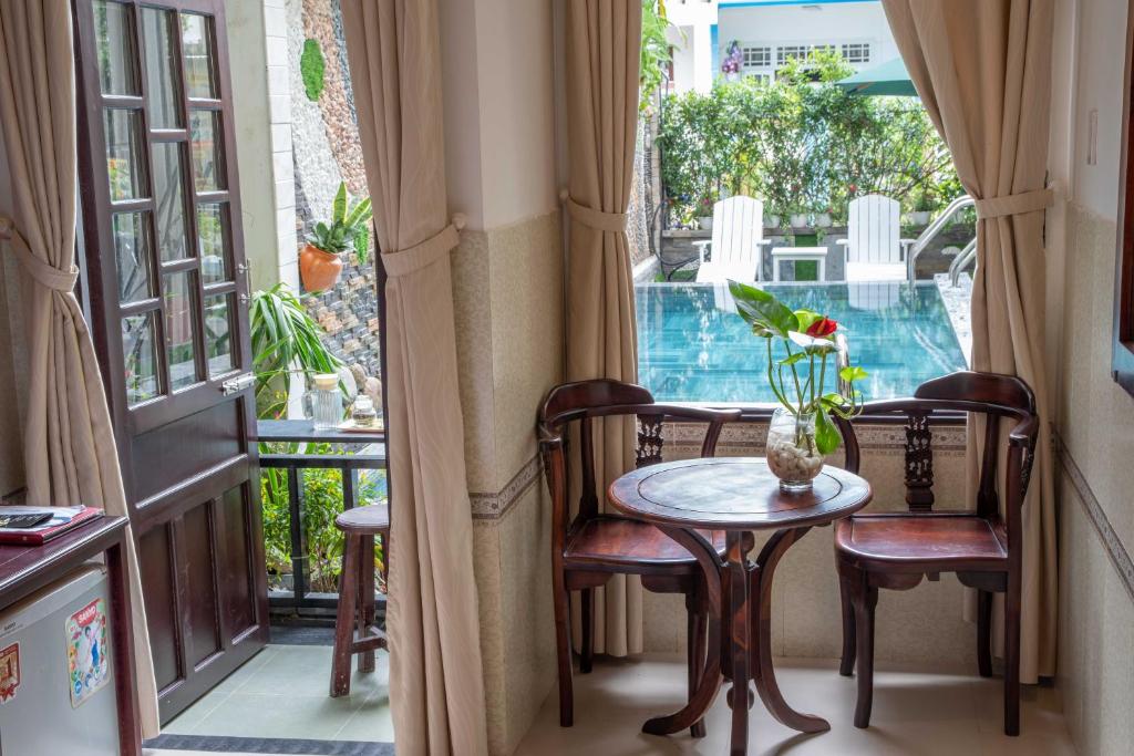 a room with a table and chairs and a window at Hoi An Ngo Homestay in Hoi An